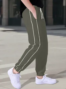 Side view detail of men's olive green joggers with white stripes and elastic cuffs