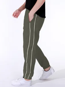 Detail view of men's olive green joggers with white side stripes and cuffed ankles.
