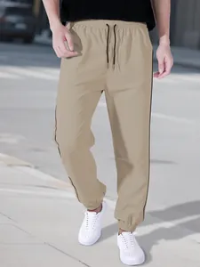 Men's khaki techwear joggers with side stripes and elastic ankle cuffs for sports