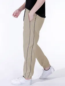 Detailed side view of khaki men's high street paratrooper pants with black stripes