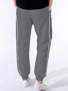 Back view of men's gray paratrooper pants with white side stripes and elastic cuffs