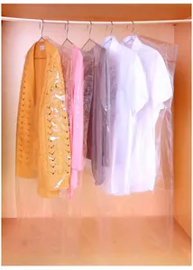 Set of clear plastic garment bags protecting shirts and sweaters in a wooden wardrobe