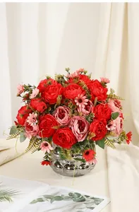 Detailed view of lifelike artificial red and pink peony bouquet in a silver vase.