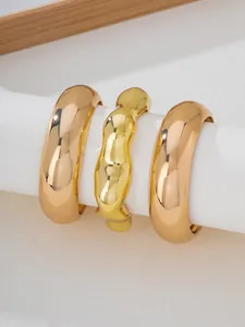 Close-up detail of 3pcs gold bangle set featuring irregular and smooth open designs