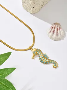 Close-up detail of a gold-plated seahorse pendant necklace with sparkling blue inlay