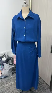 Detailed view of royal blue pleated two-piece set with long skirt and button-down shirt