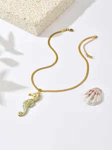 Elegant detail of a gold plated stainless steel necklace featuring a blue seahorse pendant