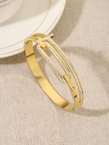 Close-up of a gold titanium steel bangle with sparkling rhinestone T-shaped design