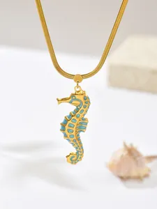 Detail view of a gold-plated stainless steel seahorse necklace with blue enamel