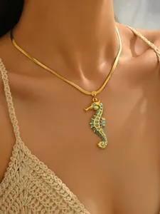 Detailed view of a gold-plated seahorse pendant necklace worn by a model in sunlight