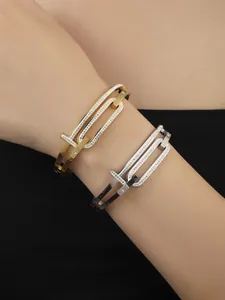 Close-up of stylish T-shaped interlocking crystal bangles in gold and silver finishes
