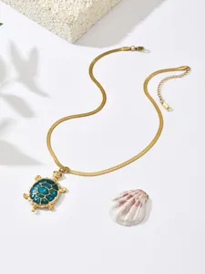 Detail view of gold-plated stainless steel turtle necklace with blue enamel pendant