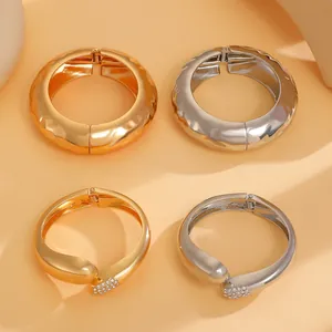 Detailansicht von gehämmerten Armreifen und Wassertropfen-Armbändern in Gold und Silber