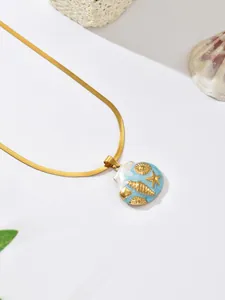 Detail view of gold-plated ocean theme necklace with blue enamel shell pendant