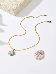 Detail of ocean-themed pendant with starfish and shell on a gold snake chain