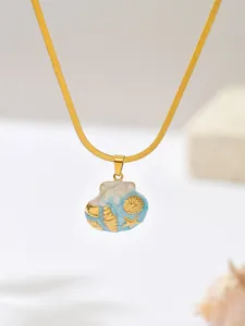 Detail view of a gold-plated ocean theme shell pendant necklace with blue enamel