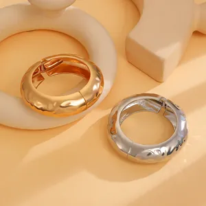 Detailansicht der unregelmäßig gehämmerten Metallarmreifen in Gold- und Silberoptik