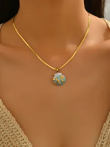 Close-up detail of a gold-plated stainless steel necklace featuring a sea shell pendant