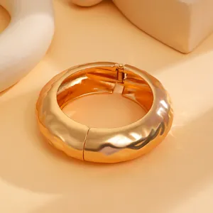 Detailansicht eines klobigen Goldarmreifs mit unregelmäßiger Hammerschlagstruktur