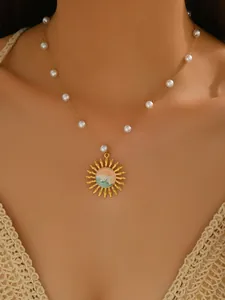 Detailed close-up of a gold-plated stainless steel necklace with sun pendant and pearls