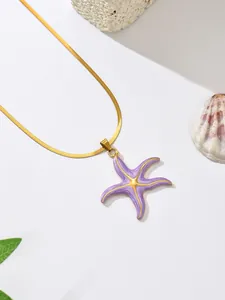 Detailed macro view of purple enamel starfish pendant on gold snake chain necklace