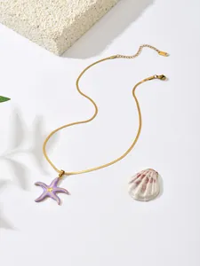Detail view of a purple starfish pendant on a gold stainless steel snake chain necklace