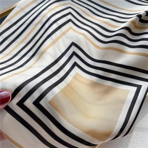 Close-up of a striped silk-like square scarf showing elegant geometric pattern and sheen