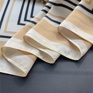 Close-up of elegant striped silk-like scarf showing fine stitching and fabric texture.