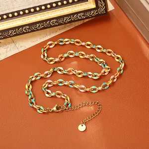 Détail d'un collier en acier inoxydable doré avec des maillons en émail multicolore