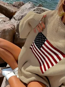 Detailed view of the American flag pattern on this loose beige retro crewneck sweater.