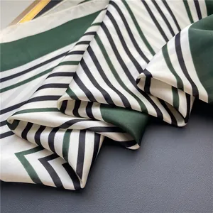 Close-up of green and black striped silk-like square scarf showing fabric texture.