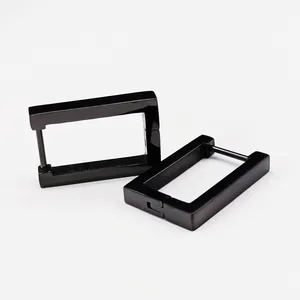A macro detailed view of minimalist black titanium steel rectangular hoop earrings
