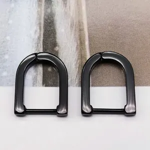 Macro detail of glossy black U-shaped titanium steel non-pierced hoop ear clips