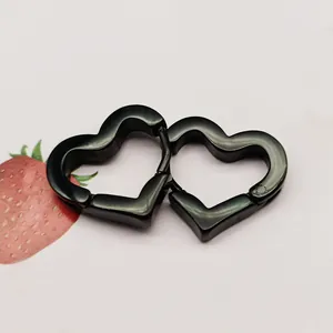 Close-up of black heart-shaped titanium steel hoop earrings on a light background