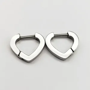 Detail view of silver-toned stainless steel heart-shaped huggie clicker earrings.
