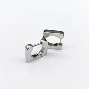 Detailed macro view of square titanium steel huggie earrings in polished silver finish