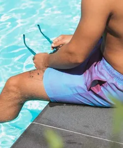 Detail view of men's color-changing swim trunks showing a blue to purple transition
