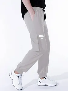 Vista dettagliata dei pantaloni cargo grigio chiaro da uomo con tasche e lacci