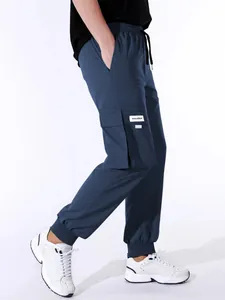 Vista laterale dei pantaloni cargo jogger blu da uomo con ampia tasca laterale e polsini