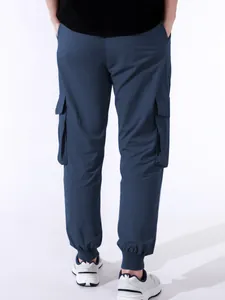 Vista posteriore di pantaloni cargo blu da uomo con tasche laterali e polsini jogger