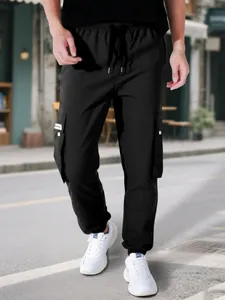 Scatto di strada professionale di pantaloni cargo neri da uomo con coulisse e tasche