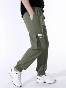 Vista laterale di pantaloni cargo verde oliva da uomo con coulisse e tasche multiple.