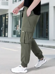 Vista laterale dei pantaloni cargo verde oliva con ampie tasche laterali e polsini elastici