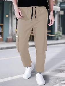 Dettaglio dei pantaloni cargo kaki da uomo con coulisse in vita e ampie tasche laterali.