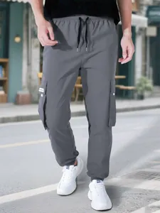 Dettaglio laterale dei pantaloni cargo grigi da uomo con coulisse e tasche utility