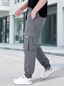Vista laterale dettagliata dei pantaloni cargo grigi da uomo con tasche e lacci