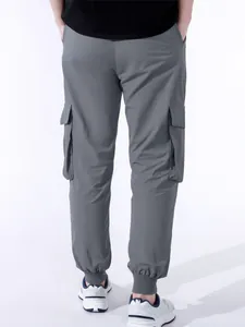 Vista posteriore di pantaloni cargo grigi da uomo con tasche e polsini elastici