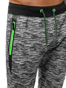 Détail d'un pantalon de jogging gris chiné avec poche zippée verte et cordon de serrage