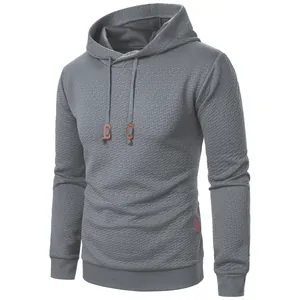 Detailed view of grey men's jacquard hoodie with textured pattern and drawstring hood
