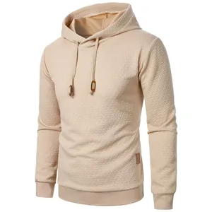 Detailed view of men's beige jacquard hoodie featuring textured fabric and adjustable drawstring